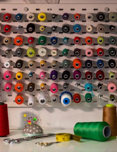 Bobines de fils utilisées pour la couture artisanale et la création de vêtements et accessoires en tissu recyclé.